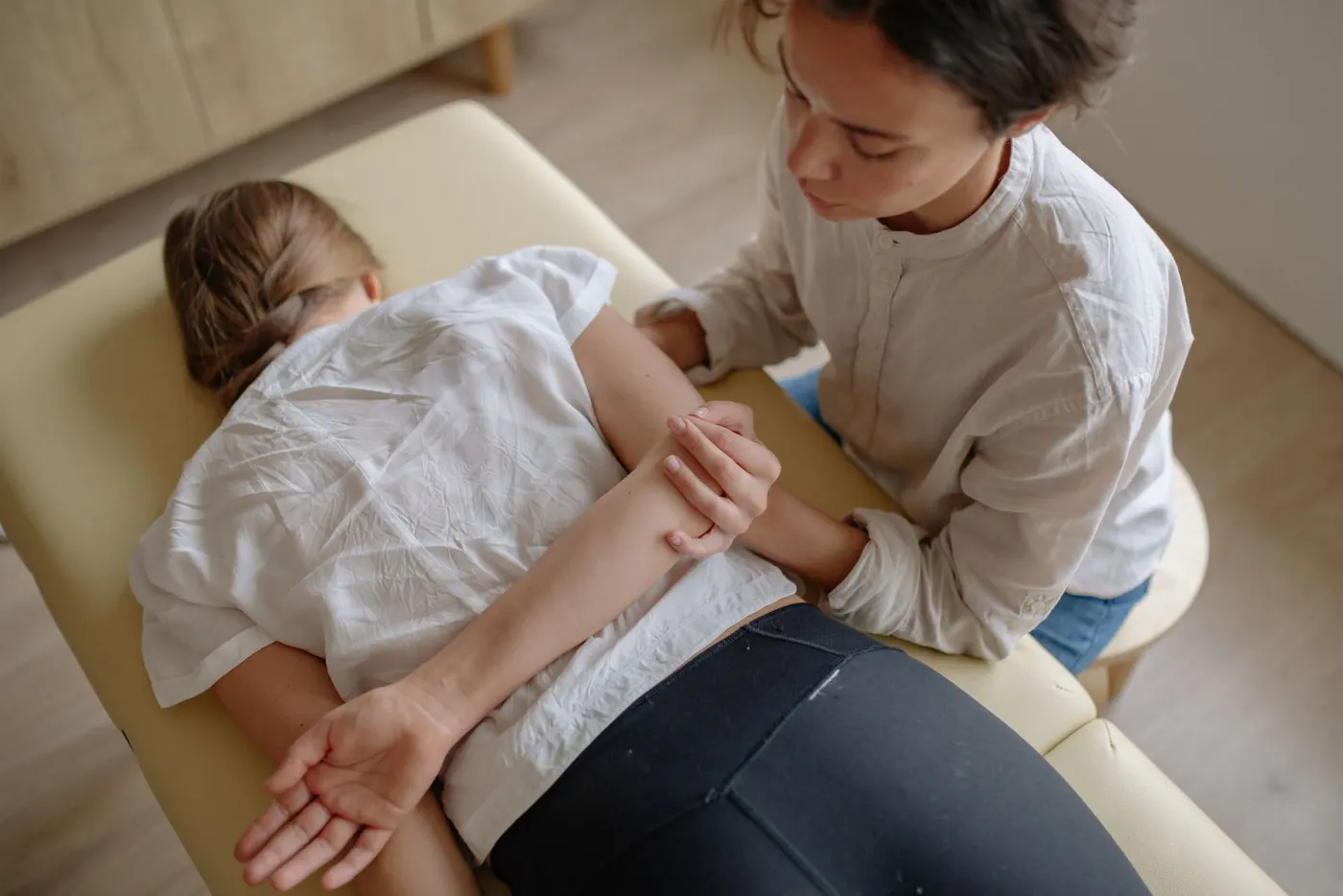 A chiropractor working on a patient's shoulder blade during treatment