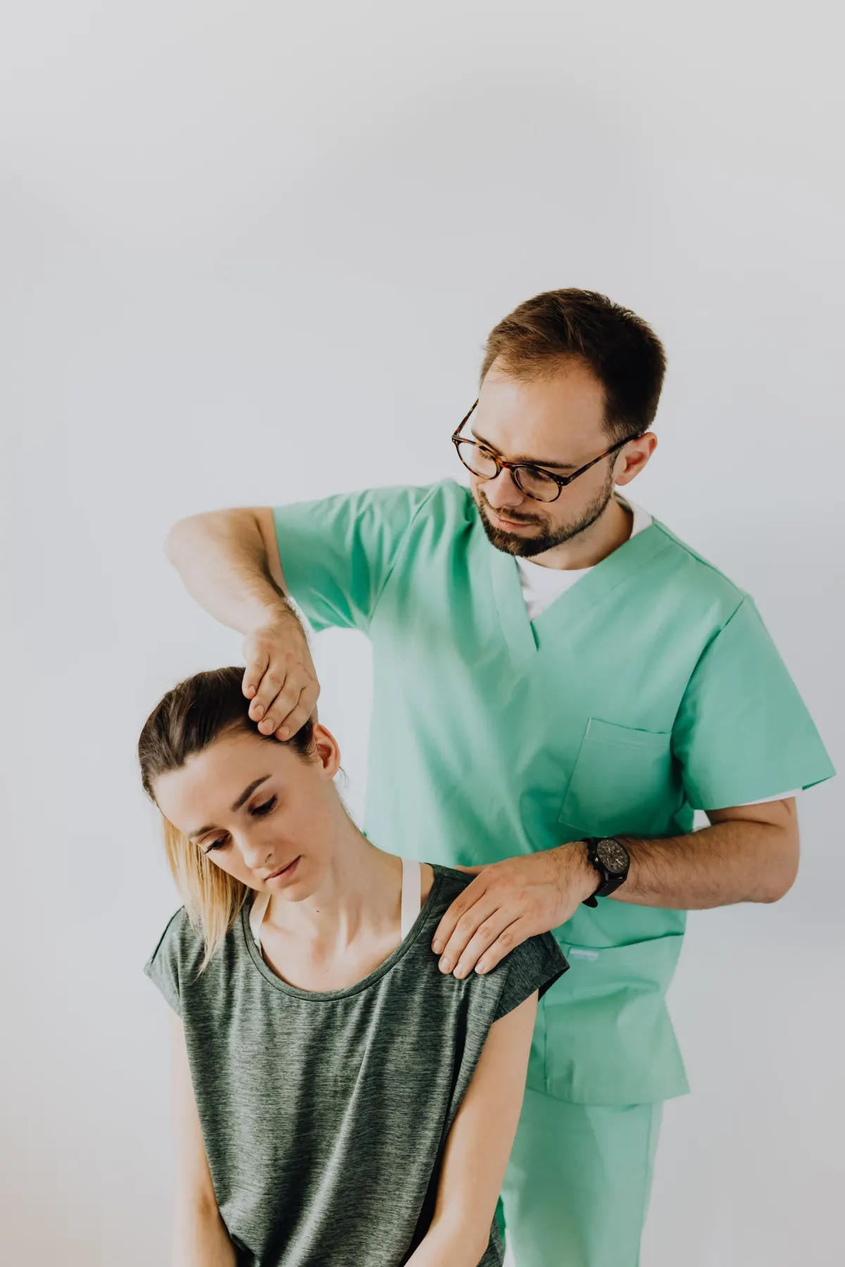 A chiropractor gently stretching a patient's neck during treatment